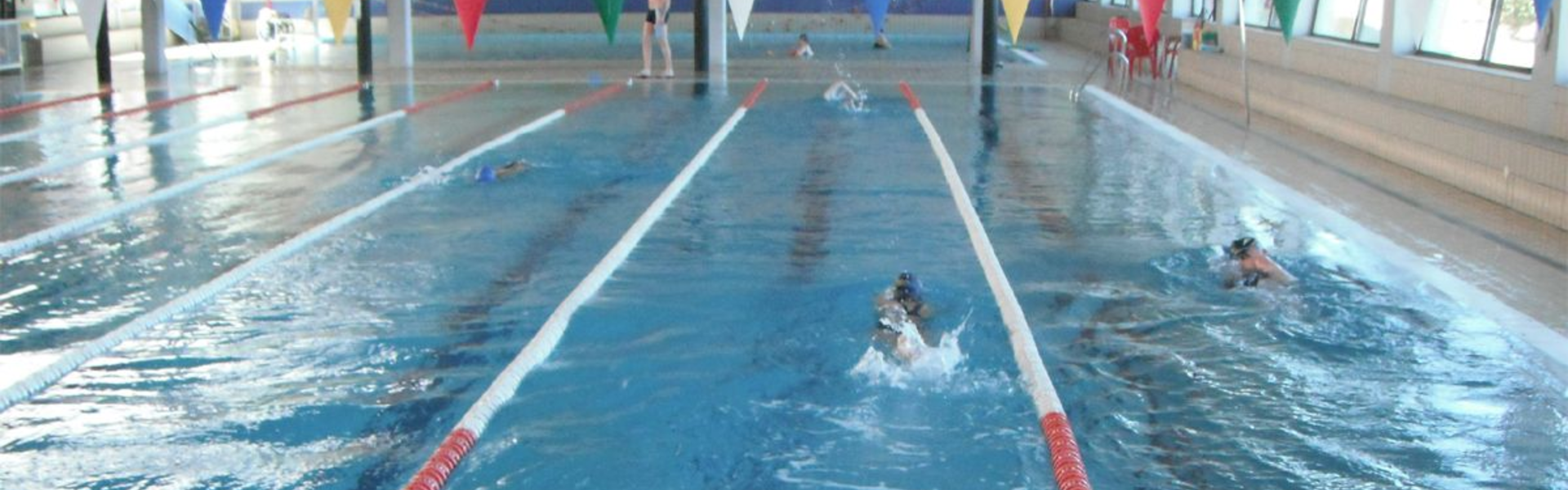 Personas nadando en la piscina municipal de Linares