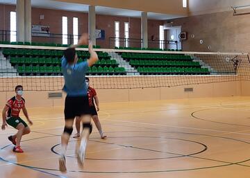 Jugador de voleibol rematando en la red