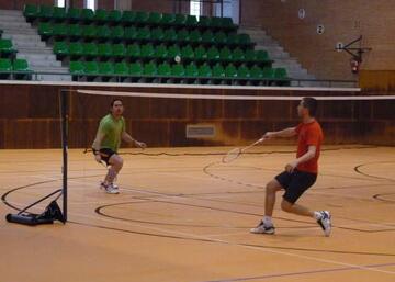 Dos jugadores de badminton disputando un partido.