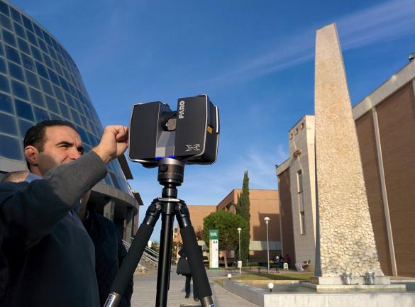 Profesor usando un escáner láser junto al edificio A4