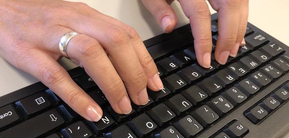 Las manos de una chica joven sobre el teclado.