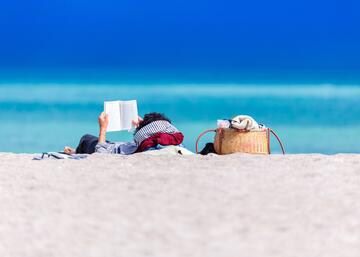 Chica leyendo en la playa