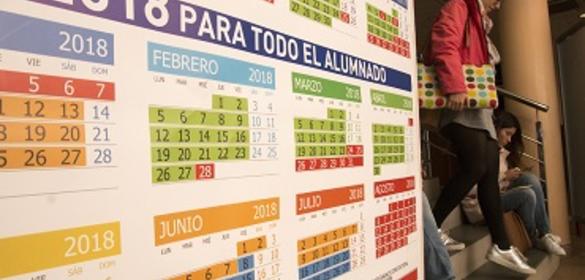 Varios alumnos al lado de una panel informativo con el calendario académico