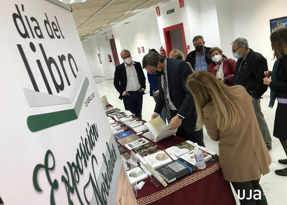 El Rector hojea un libro.