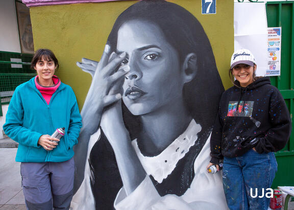 Las dos artistas posan ante el retrato de Ángeles Toledano. Fotografía: Fernando Mármol.
