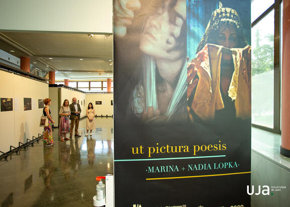 Un momento de la inauguración de la exposición, con su cartel en primer plano.