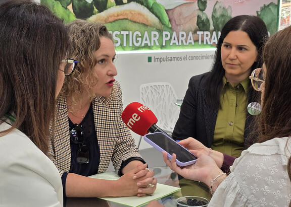 La investigadora Eva Montes, atendiendo a los medios de comunicación en el stand de la UJA en Expoliva.