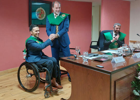 El Rector Nicolás Ruiz impone la beca al conferenciante Francisco Salinas.