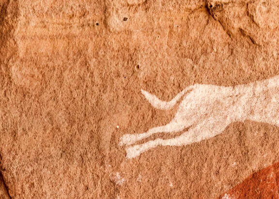 Una cazador con dos perros, representados en las cuevas rupestres de Tadrart Acacus (Libia). Giampaolo Cianella/Shutterstock.