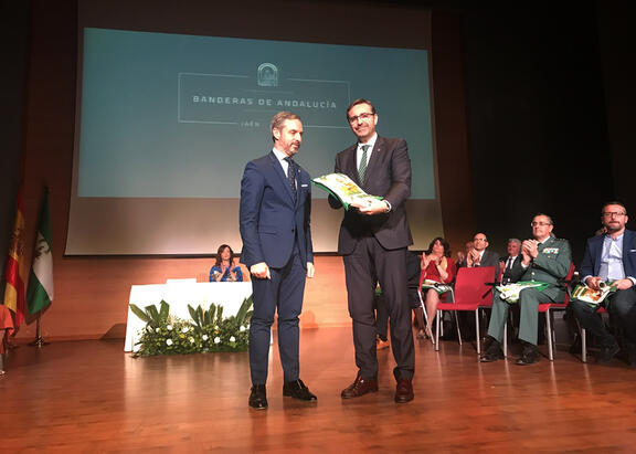 Juan Gómez recibe la Bandera de Andalucía de manos de Juan Bravo Baena.