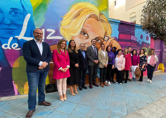 Representantes institucionales, familiares y compañeros, junto al mural.