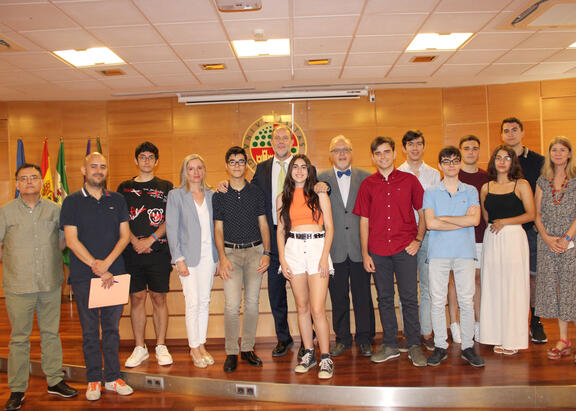 El Rector, en el centro, con representantes institucionales y de las olimpiadas, junto con el alumnado premiado.